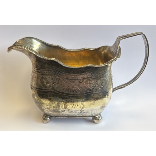 Victorian silver cream jug with engraved decoration on four ball feet