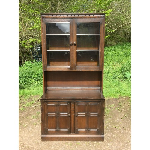 Ercol glazed and shelved dresser in light wood with upper display section over lower cupboard base