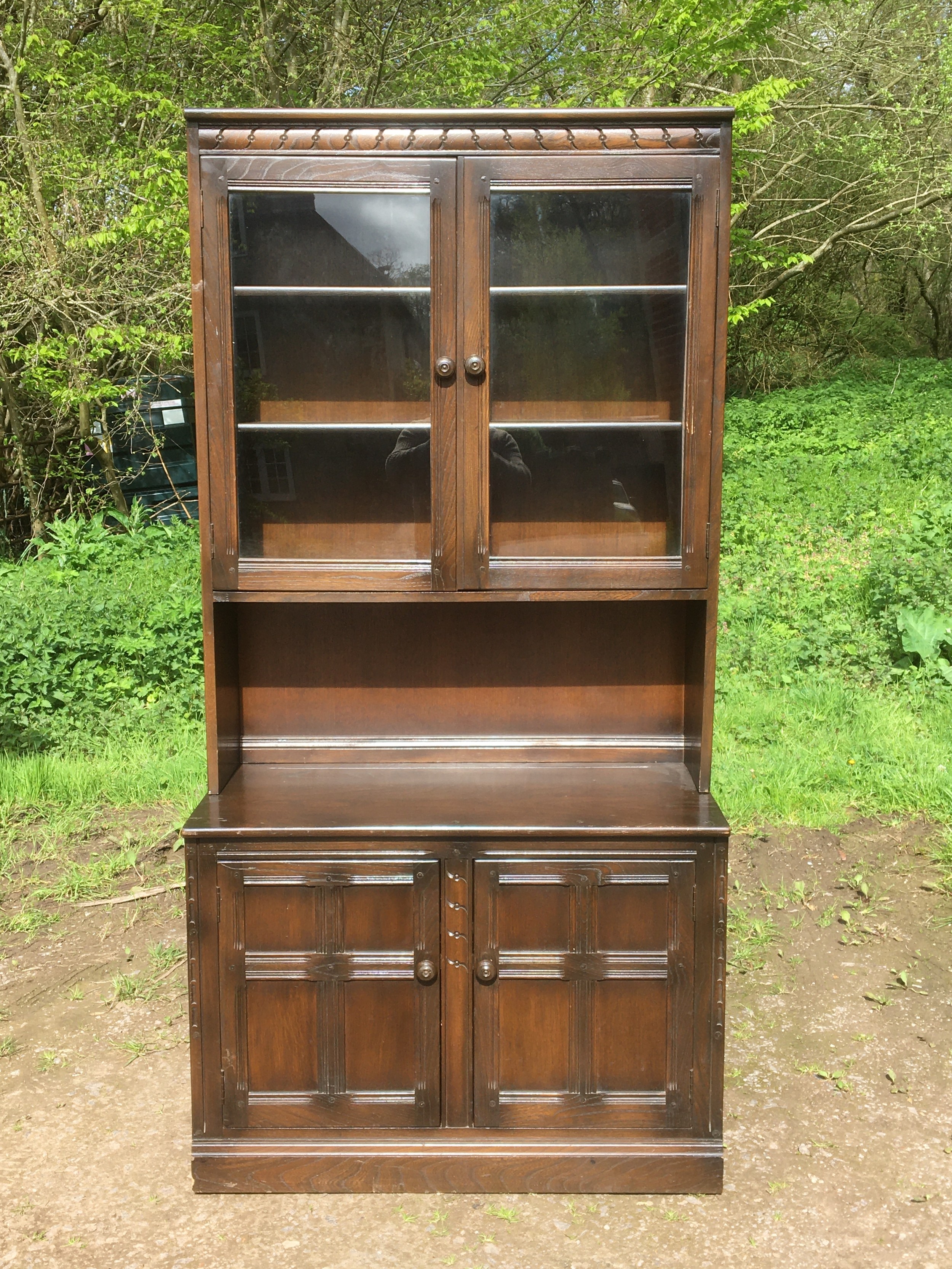 Ercol glazed and shelved dresser in light wood with upper display section over lower cupboard base