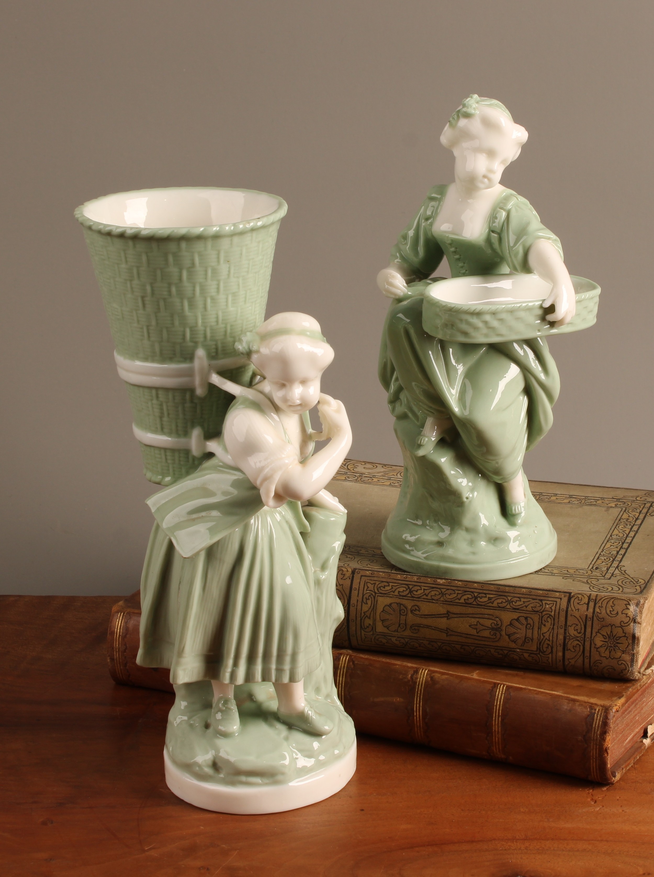 Late 19th-century Minton celadon-glazed figural spill vase with basket-carrying girl and companion figure
