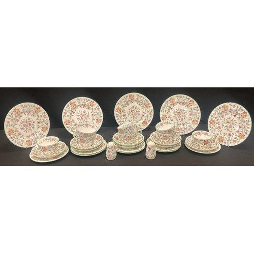 Minton Haddon Hall tea service with cups, saucers, and floral plates arranged across a table