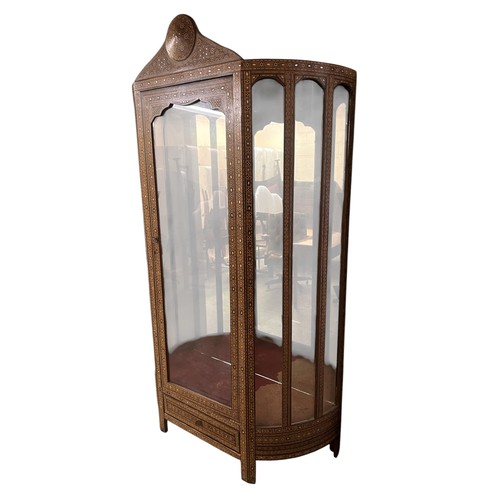 Tall Damascus inlaid display cabinet in the Moorish style with arched columns, a shaped pediment, and dense mother-of-pearl decoration