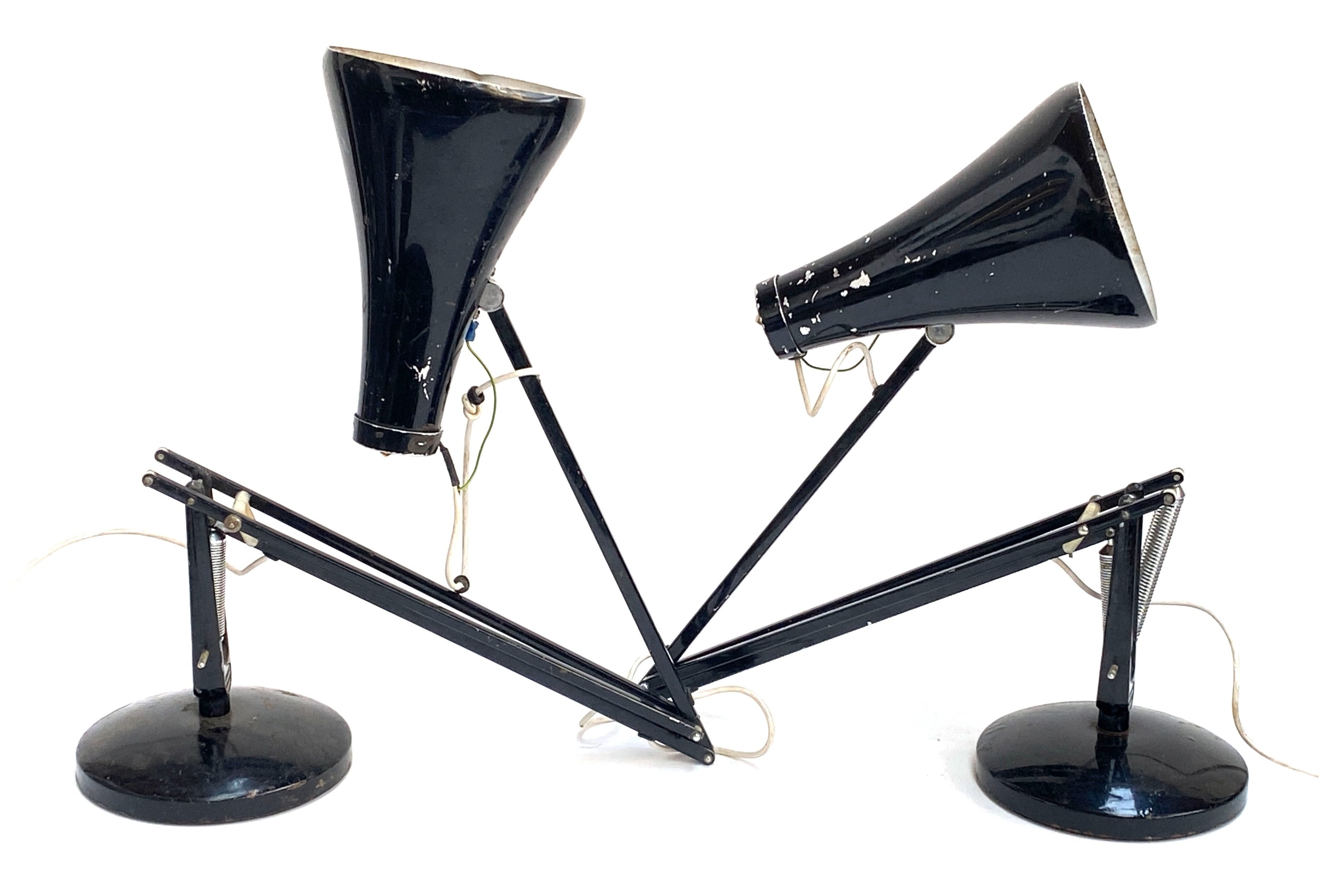 Pair of vintage black Herbert Terry Anglepoise lamps with rounded black bases, spring-balanced arms, chipped shades, and exposed wiring