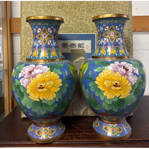 Pair of Chinese cloisonne enamel vases with floral and bird decoration on a blue ground