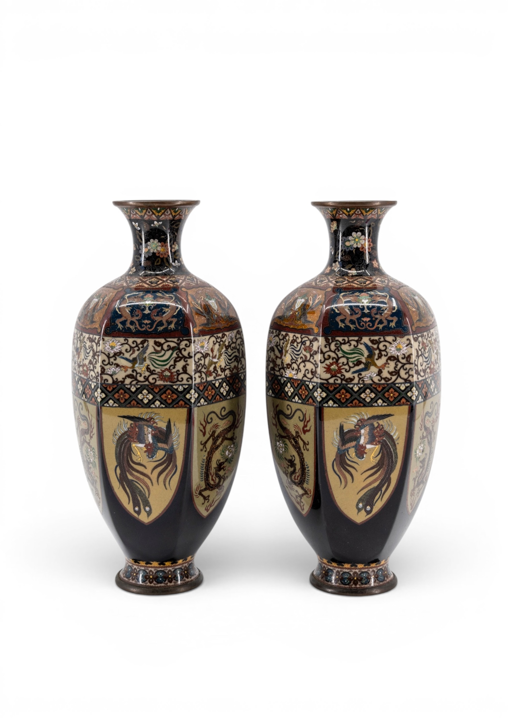 Pair of Japanese Meiji cloisonn&eacute; vases with black grounds, cream figural panels, ho-o birds, dragons, and geometric border bands