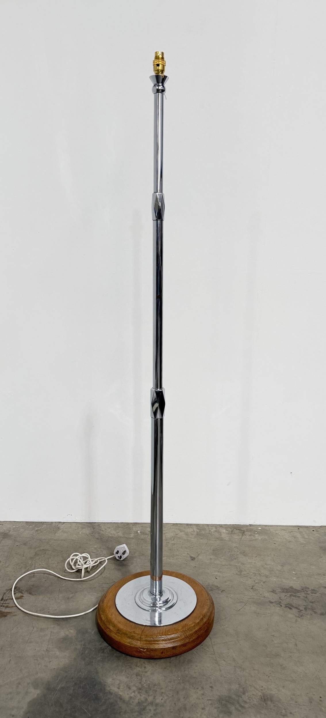 Art Deco chrome standard lamp with stepped cylindrical pillar, faceted diamond-shaped junctions, and a round oak base